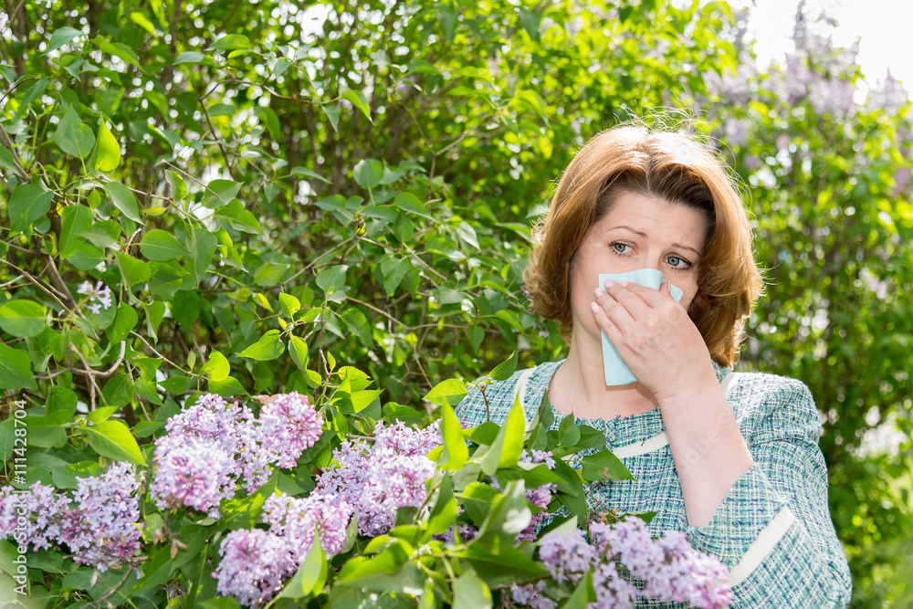 Woman suffering from pollen allergy about lilacs Woman suffering from pollen allergy about lilacs