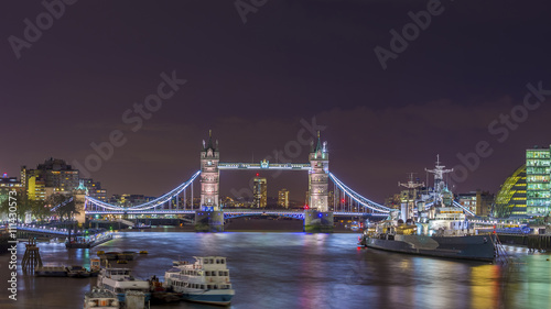London, England - The Iconic Tower Bridge and HMS Belfast cruiser ship on River Thames by night