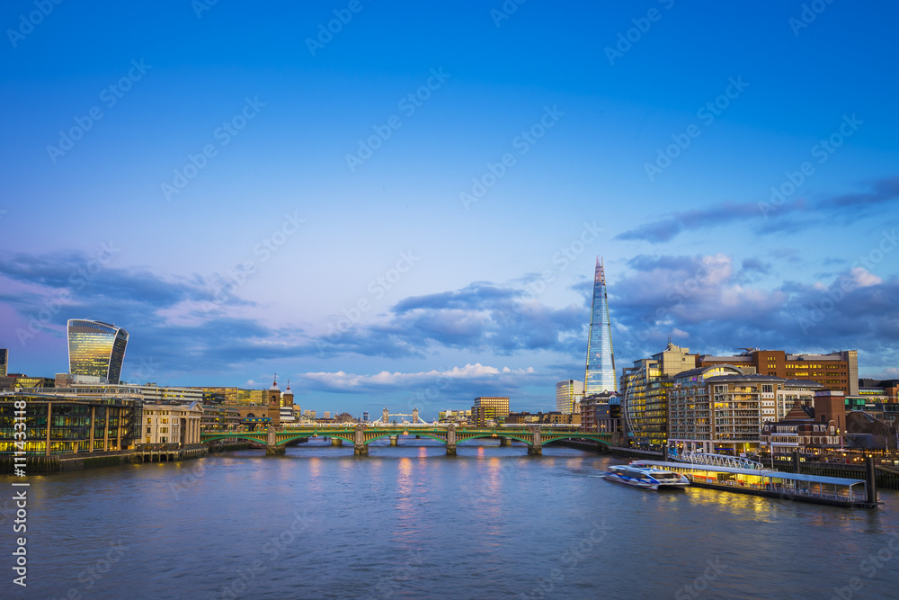 London's skyline view with famous skyscrapers and Tower Bridge, shot from Millennium Bridge