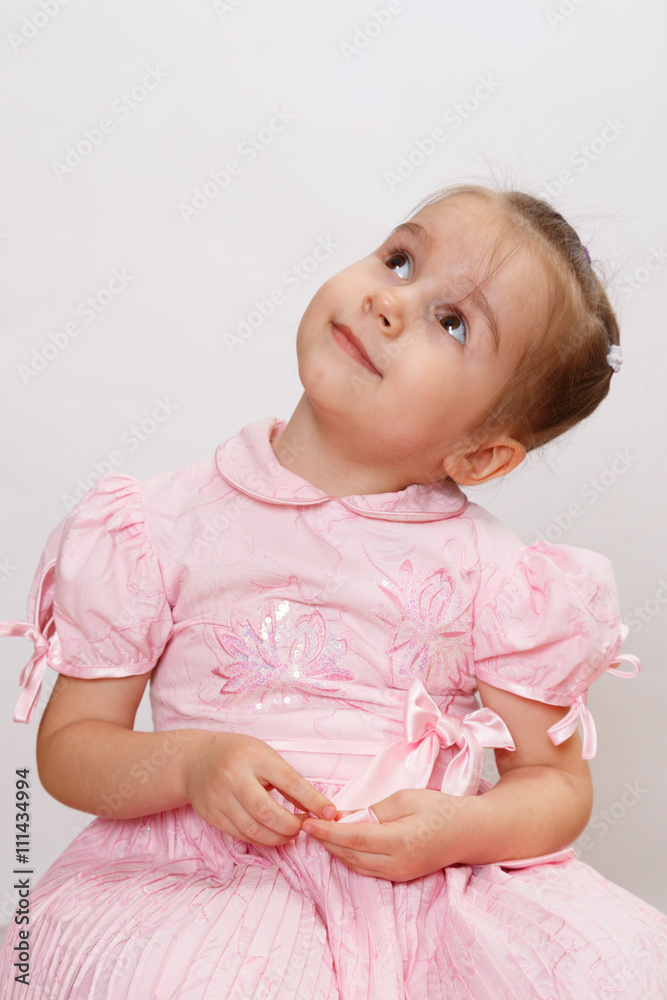 Happy smiling little girl is looking at the left side and up. Cheerful kid. Happy smiling little girl is looking at the left side and up. Cheerful kid.