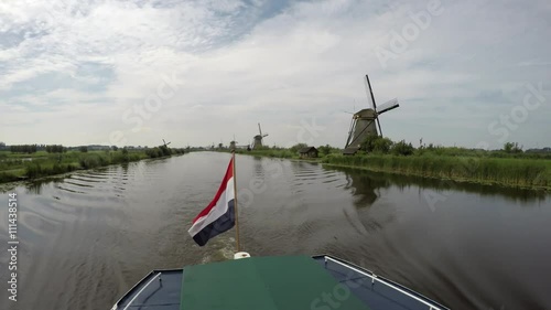 Dutch flag on the back of a boat on a canal in Kinderdijk Childrens Dike windmills Unesco World Heritage Unique Dutch sight and the most popular tourist attraction in Holland The Netherlands 4k photo