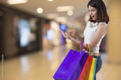 young woman using mobile phone in modern shopping mall.