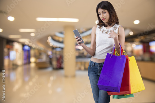 young woman using mobile phone in modern shopping mall.