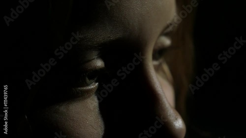 Depressed teenager is sad and guilty. Focused on eye, extreme closeup. 4K UHD.