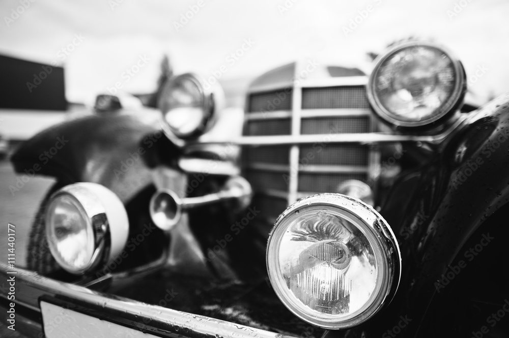Old vintage car headlight close up. Black and white photo