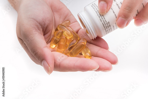 Omega 3 fish oil capsule hold by a hand