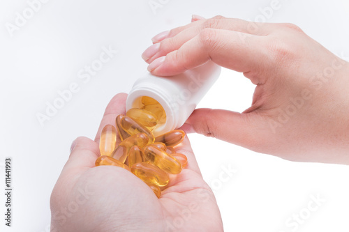 Omega 3 fish oil capsule hold by a hand