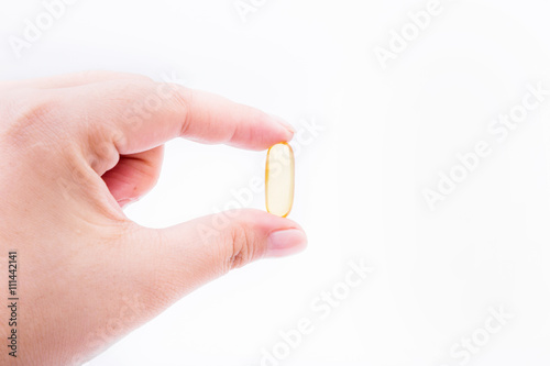 Omega 3 fish oil capsule hold by a hand