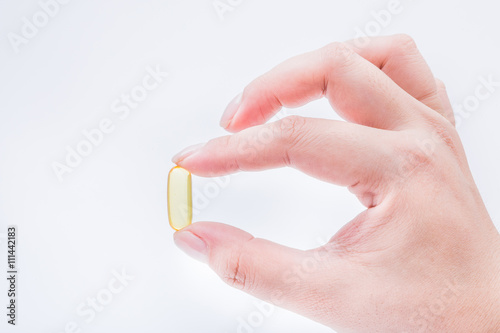 Omega 3 fish oil capsule hold by a hand