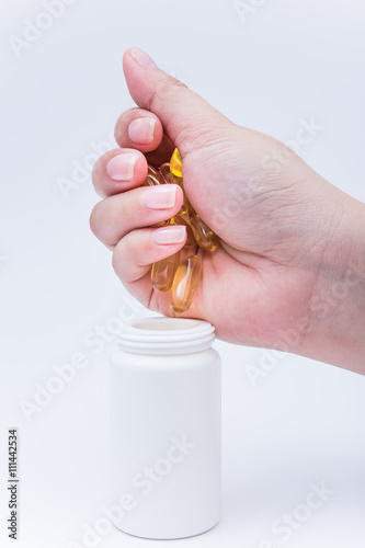 Omega 3 fish oil capsule hold by a hand