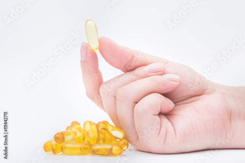 Omega 3 fish oil capsule hold by a hand