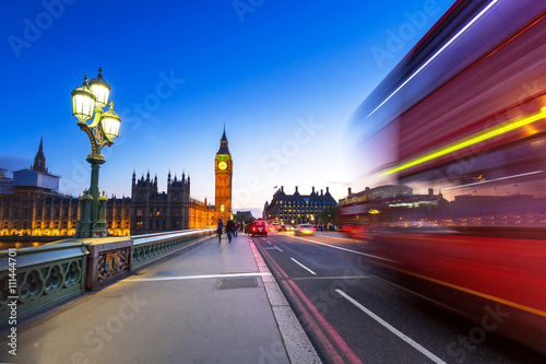 London scenery at Westminster bridge with Big Ben and blurred red bus, UK