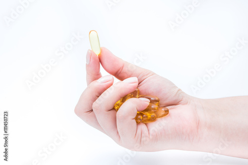 Omega 3 fish oil capsule hold by a hand