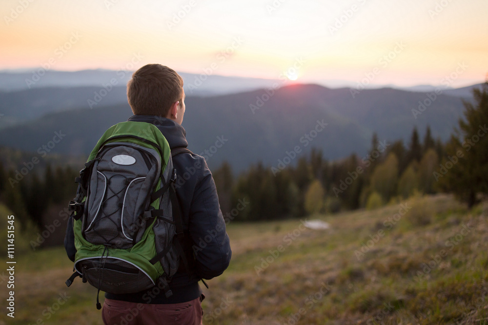 Man enjoying mountain sunset and looking at the distance