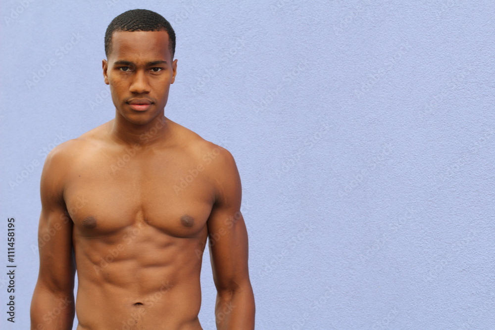 Beautiful muscular black male model with nice abs and v isolated on blue with copy space