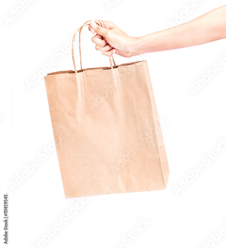 hand holding brown paper shopping bag on white background