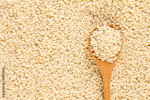 close up sesame in wooden spoon on white sesame seeds surface te