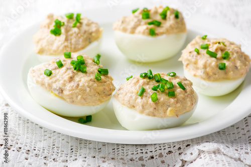  delicious stuffed eggs on white plate.