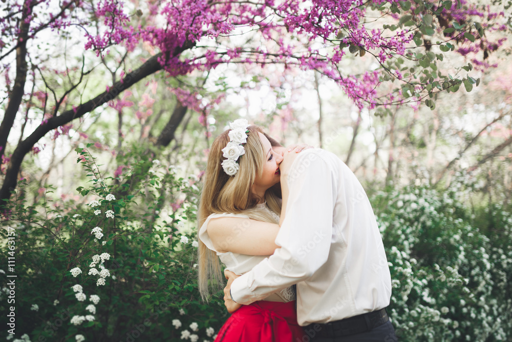 Stylish beautiful happy wedding couple kissing and embracing in Botanical Garden Stylish beautiful happy wedding couple kissing and embracing in Botanical Garden