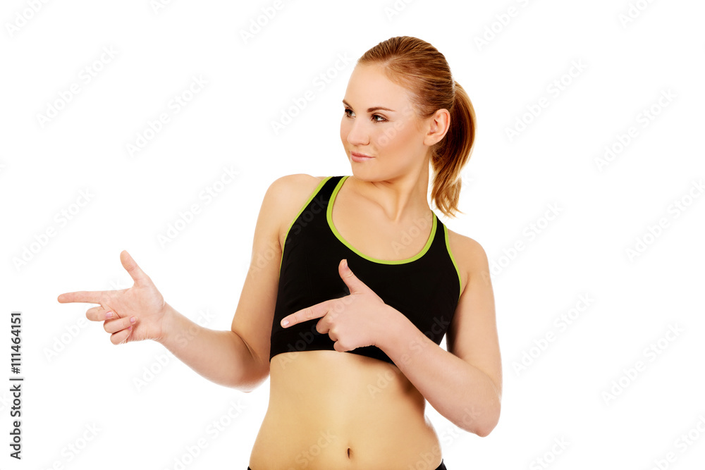 Young athletic woman pointing for copyspace or something Young athletic woman pointing for copyspace or something