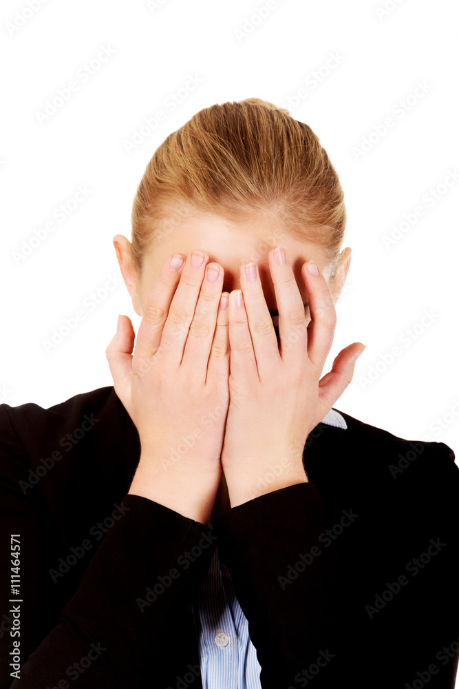 Troubled business woman covering her face with hands Troubled business woman covering her face with hands