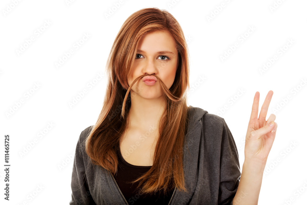 Funny teen woman putting hair like mustache Funny teen woman putting hair like mustache