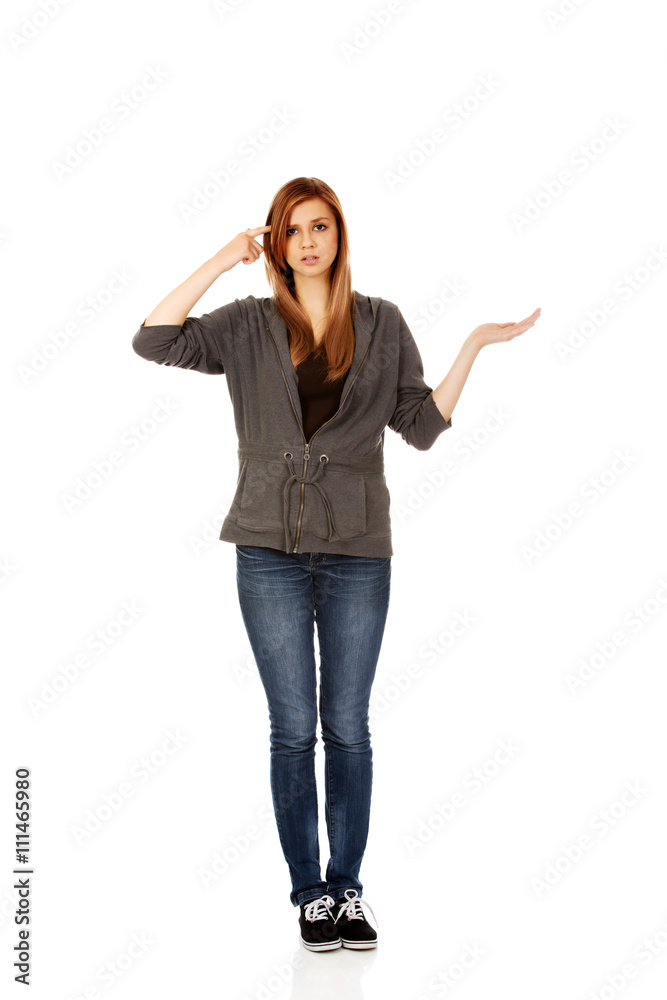 Teenage woman holding something on open palm and thinking about something Teenage woman holding something on open palm and thinking about something
