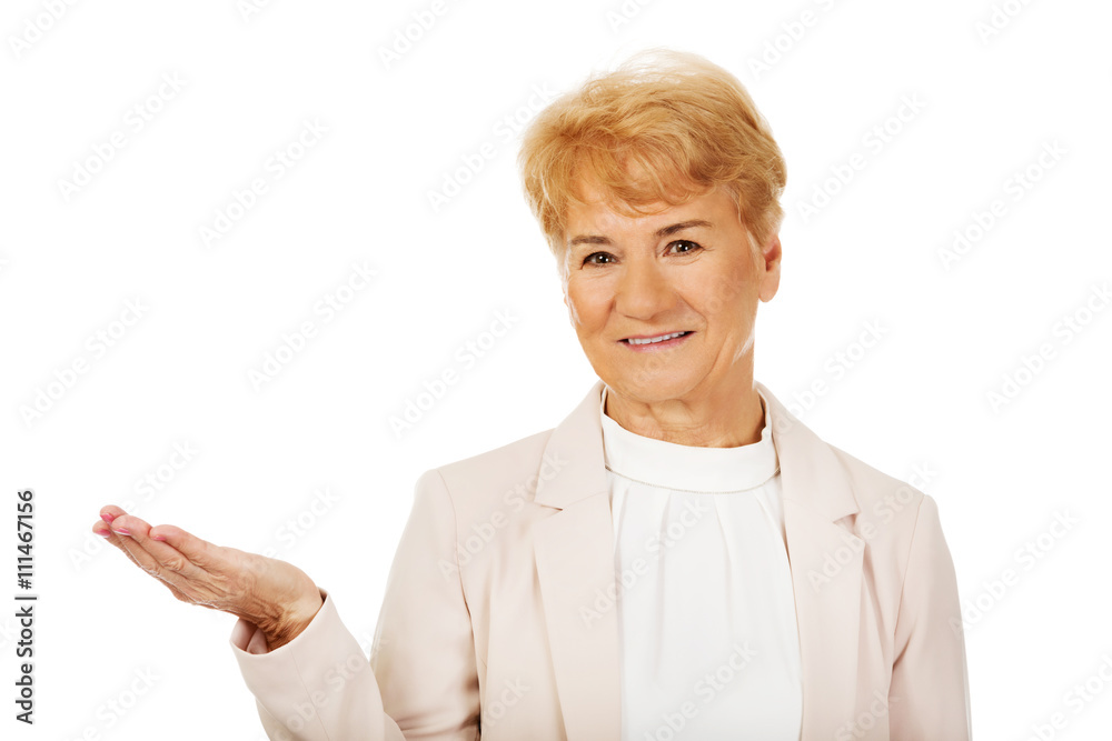 Smile senior woman holding something on open palm Smile senior woman holding something on open palm