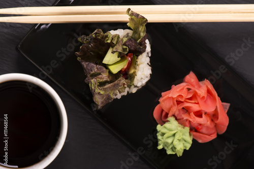 Vegetarian sushi roll over black stone table