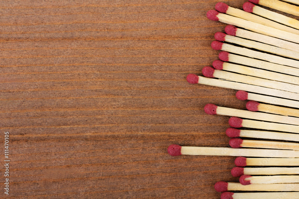 new matches scattered on a brown wooden background new matches scattered on a brown wooden background