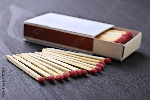 matchbox with matches on black wooden table