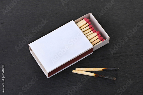 matchbox with matches on black wooden table