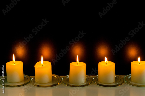 closeup to burning candles in darkness