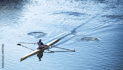 Person sculling in a racing canoe