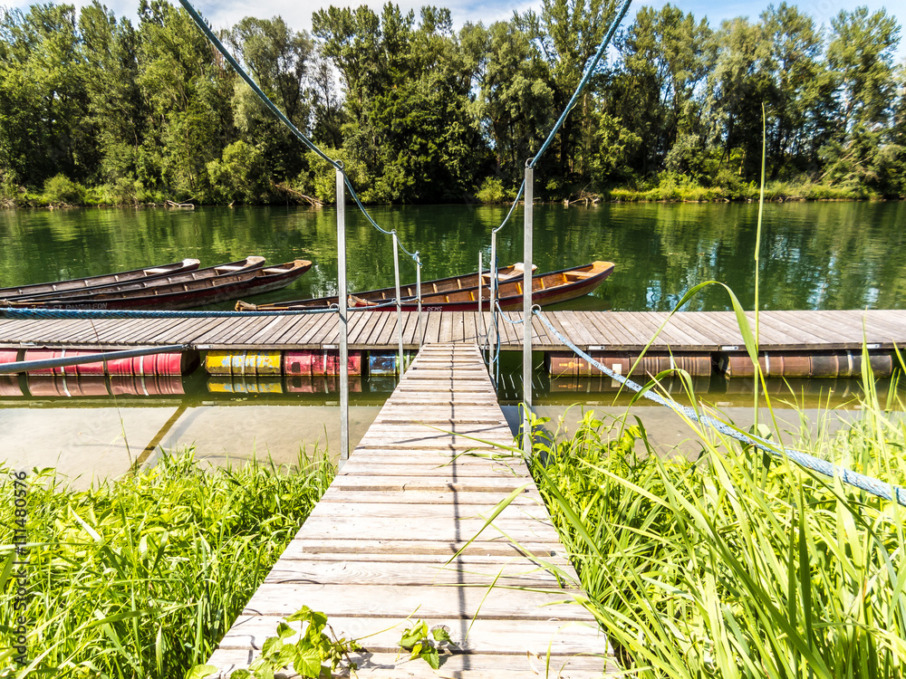 Obraz premium Heißer Sommertag am Hafen mit Holzbooten an einem Fluss
