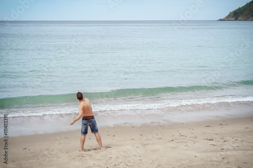 Man plays throwing rocks at the beach on vacation © carlosobriganti