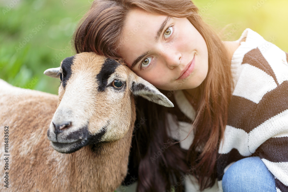 woman is stroking a brown sheep