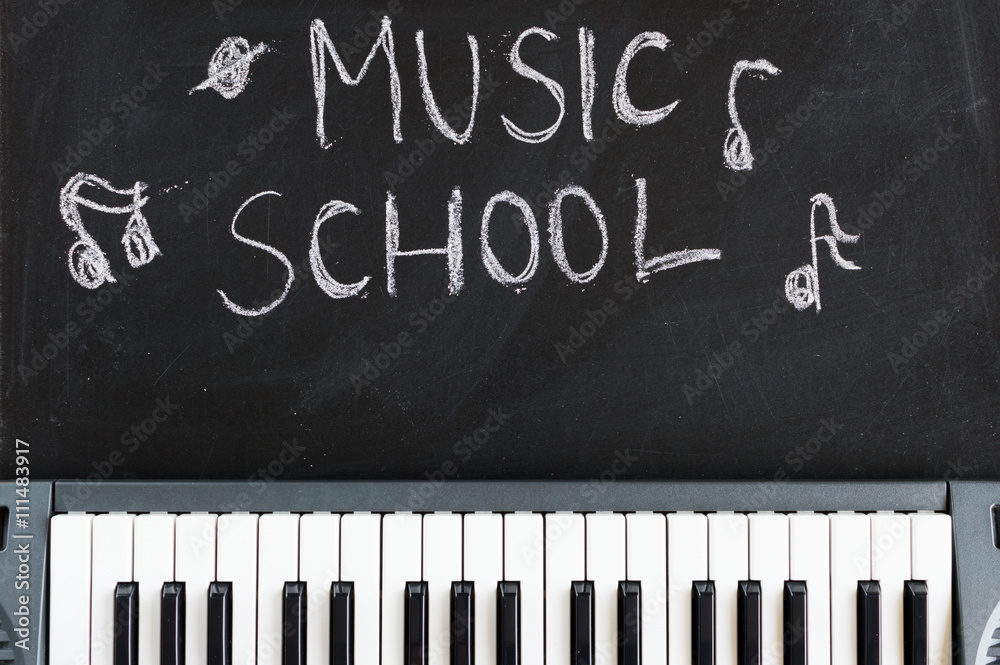 Fototapeta premium Music keyboard on blackboard background for music school children with copy space