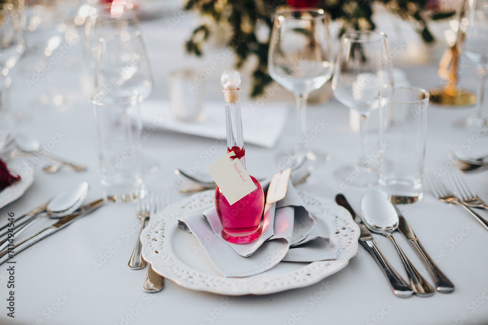 Wedding. Banquet. Grain. Artwork. At the banquet table with tablecloth colors Marsala, is the composition of flowers and greenery, cutlery and candles Wedding. Banquet. Grain. Artwork. At the banquet table with tablecloth colors Marsala, is the composition of flowers and greenery, cutlery and candles