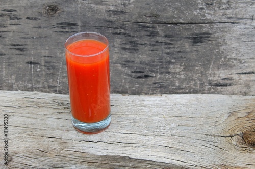 Tomato juice on wooden background 