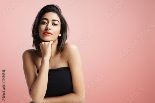 pretty young woman with strobing ideal skin on a pink background