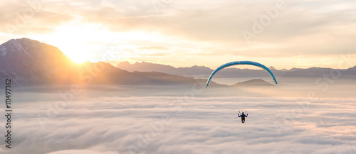 Man paragliding above clouds, Alps, Salzburg, Austria photo