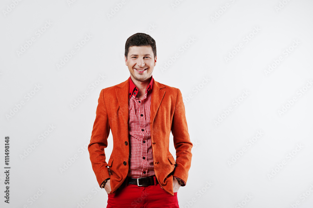 Fashion laughing young man in orange suit and red pants casual p Fashion laughing young man in orange suit and red pants casual p