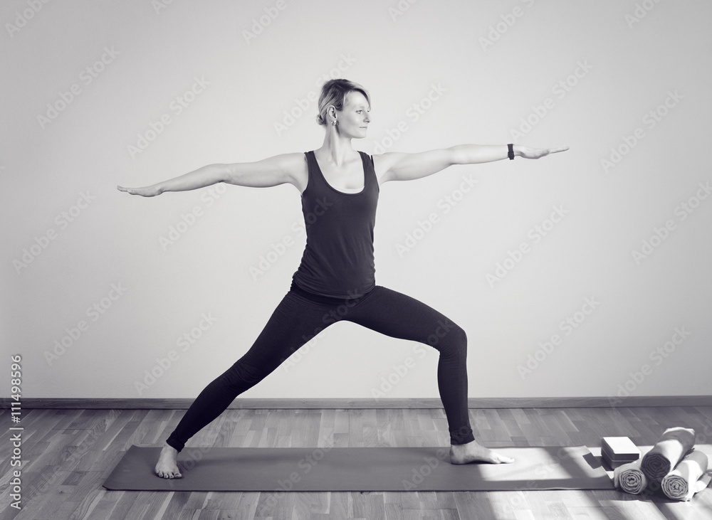 Frau die Yoga macht im stehen auf Yogamatte
