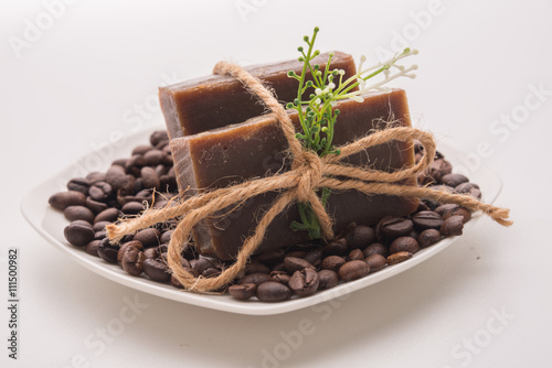 Traditional home made natural coffee soap with a pile of coffee beans on the background suggesting healthy organic non toxic wash products