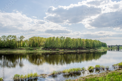 View above big beautiful river with blue sky and green grass in Belarus, Polotsk.