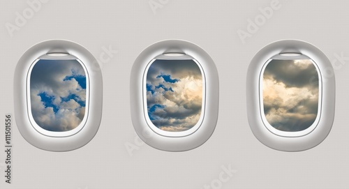 Looking out the windows of a plane to a blue sky and clouds