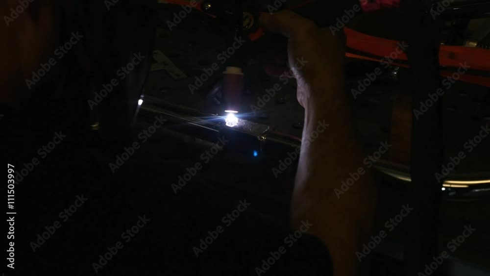A man welding steel parts in a machine shop A man welding steel parts in a machine shop