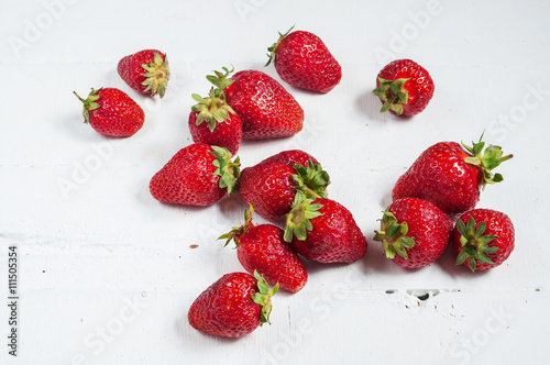 Fresh and juicy strawberries on a white wooden background