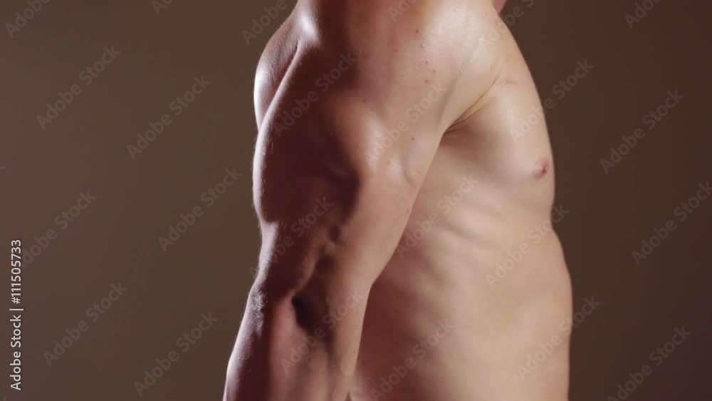 Brutal guy showing his muscles. Triceps. Graded version